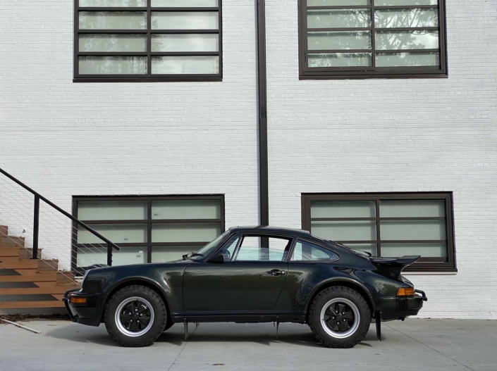 side view of a Custom Built 1986 Porsche 930 Turbo with Oak Green Metallic Exterior and Porsche tartan interior parked in front of a house