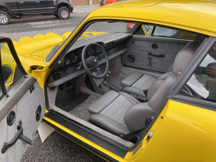 Custom Built 1988 Porsche 911 Carrera with Cadmium Yellow exterior and Opel fabric interior with the door open showcasing the front interior