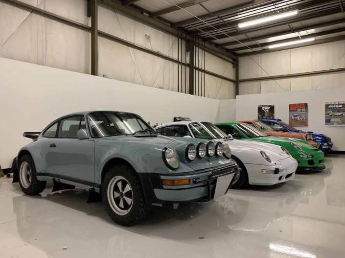 Custom Built 1988 Porsche 930 Turbo with Meissen Blue exterior and Carrera fabric interior parked inside a studio garage
