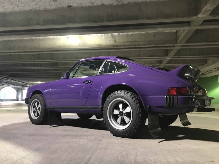 3/4 side view of a Custom Built 1978 Porsche 911 SC with Lilac exterior and Pascha interior in a parking garage