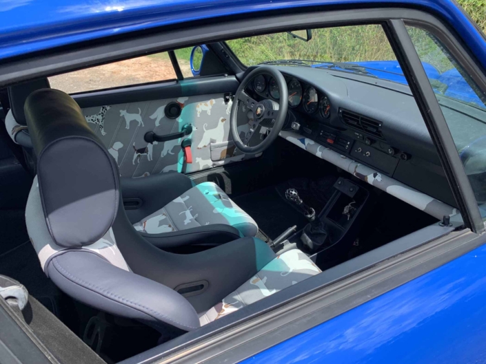 open window on a Custom Built 1988 Porsche 911 Carrera in Acid Blue with Dog fabric interior showcasing the front seating
