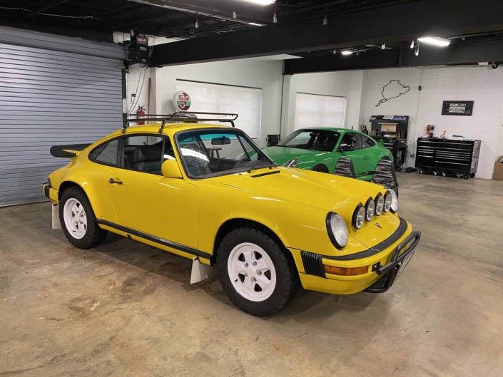 Custom Built 1988 Porsche 911 Carrera with Cadmium Yellow exterior and Opel fabric interior parked in a garage