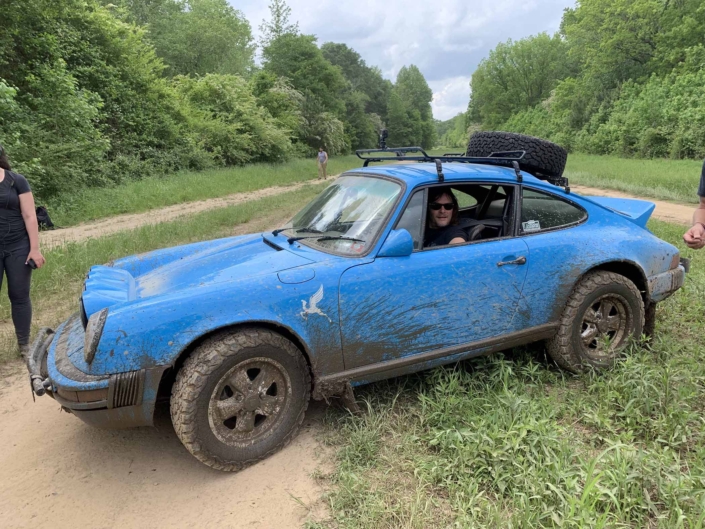 side view of a Custom Built 1980 Porsche 911 SC in Riviera Blue after driving through mud