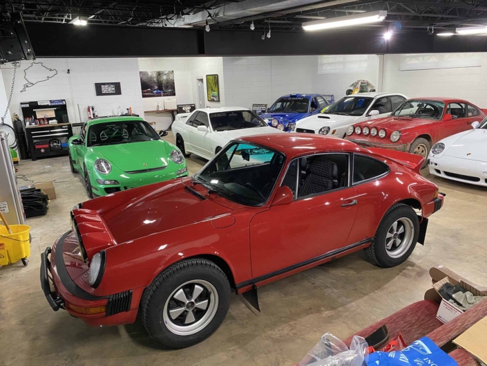 Custom Built 1987 Porsche 911 Carrera with Cherry Red exterior and VW retro interior parked in a garage