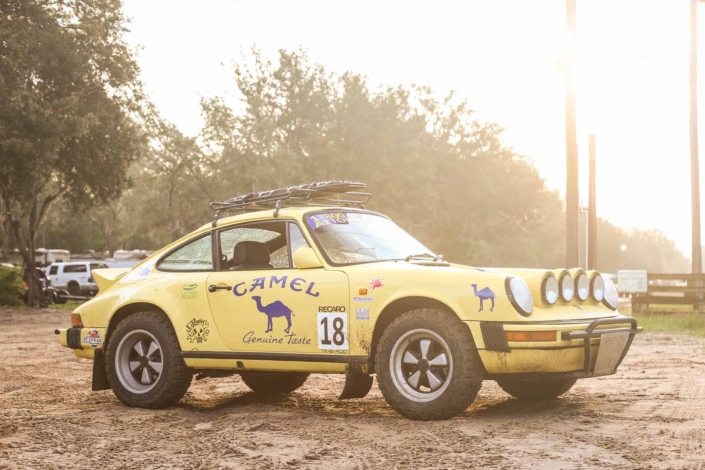 Custom Built 1984 Porsche 911 Carrera Euro with Hellgelb Exterior and Mercedes Tartan Interior parked in front of trees during a sunset