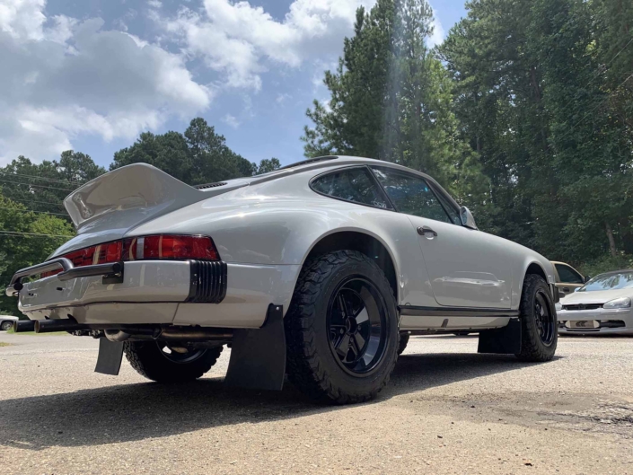 3/4 rear view of a rear view of a custom 1986 Porsche 911 Carrera with Chalk exterior color and Porsche Pepita interior