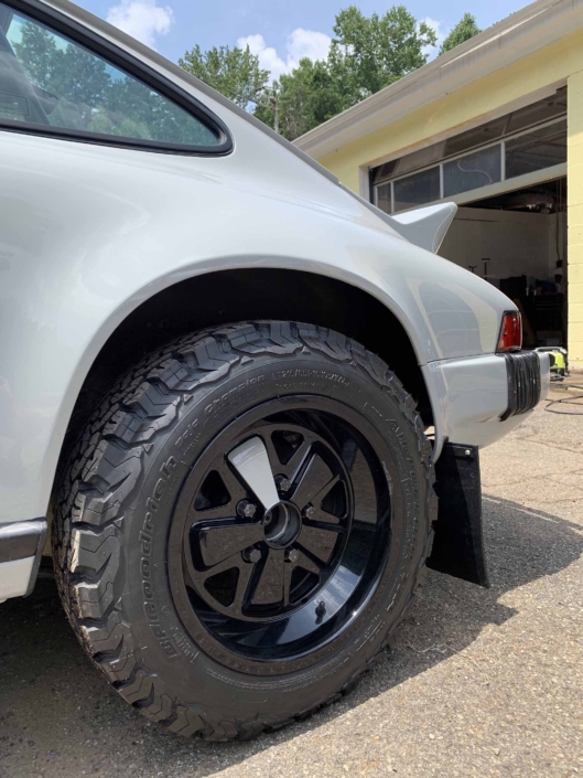 tire shot of a rear view of a custom 1986 Porsche 911 Carrera with Chalk exterior color and Porsche Pepita interior