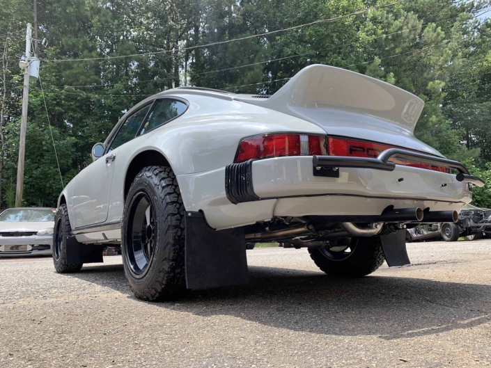 rear view of a rear view of a custom 1986 Porsche 911 Carrera with Chalk exterior color and Porsche Pepita interior