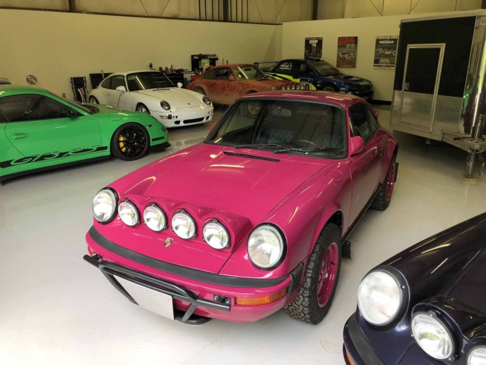 Custom Built 1988 Porsche 911 Carrera with Ruby Stone Exterior and Mercedes Fabric Interior parked in a garage