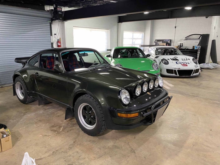 Custom Built 1986 Porsche 930 Turbo with Oak Green Metallic Exterior and Porsche tartan interior in a showcase room