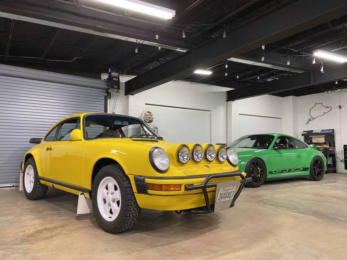 Custom Built 1988 Porsche 911 Carrera with Cadmium Yellow exterior and Opel fabric interior parked in a garage