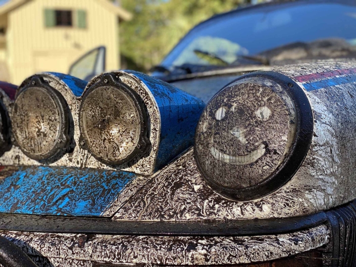 muddy headlight of a Custom Built 1982 Porsche 911 SC with Brumos Livery Exterior and Porsche Tartan Interior