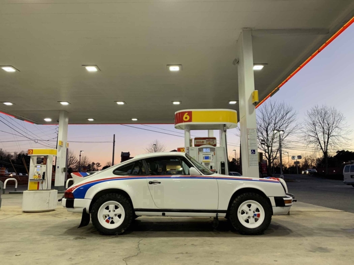 side view of a Custom Built 1982 Porsche 911 SC with Brumos Livery Exterior and Porsche Tartan Interior parked at a gas station