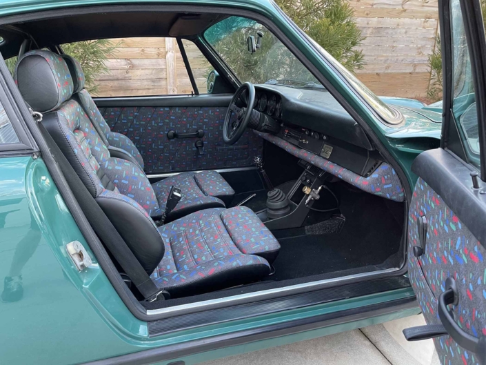 Custom Built 1974 Porsche 911 in Smyrna Green with Fiat fabric with the door open showcasing the custom interior