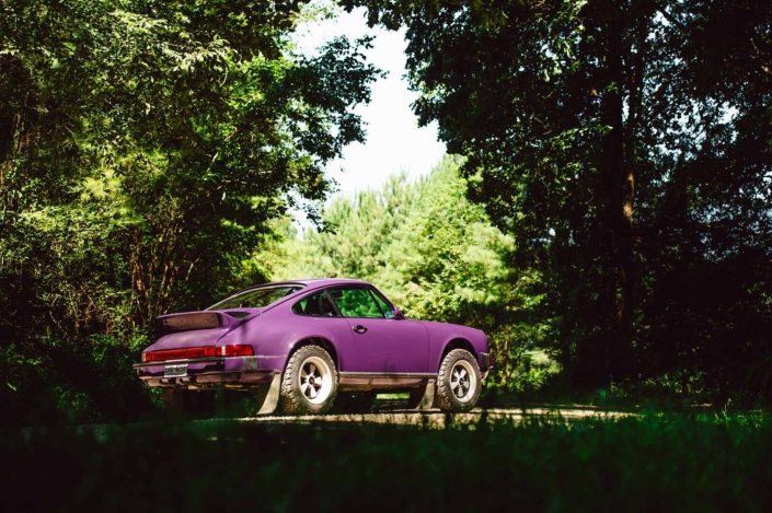 3/4 side view of a Custom Built 1978 Porsche 911 SC with Lilac exterior and Pascha interior in the woods