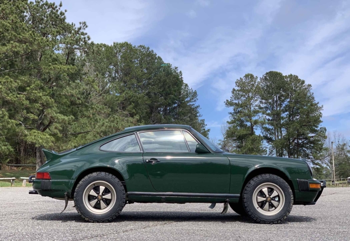 side view of a Custom built 1982 Porsche 911 SC in Irish Green with VW tartan interior parked in a parking space