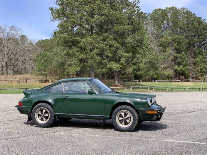 Custom built 1982 Porsche 911 SC in Irish Green with VW tartan interior parked in a parking lot