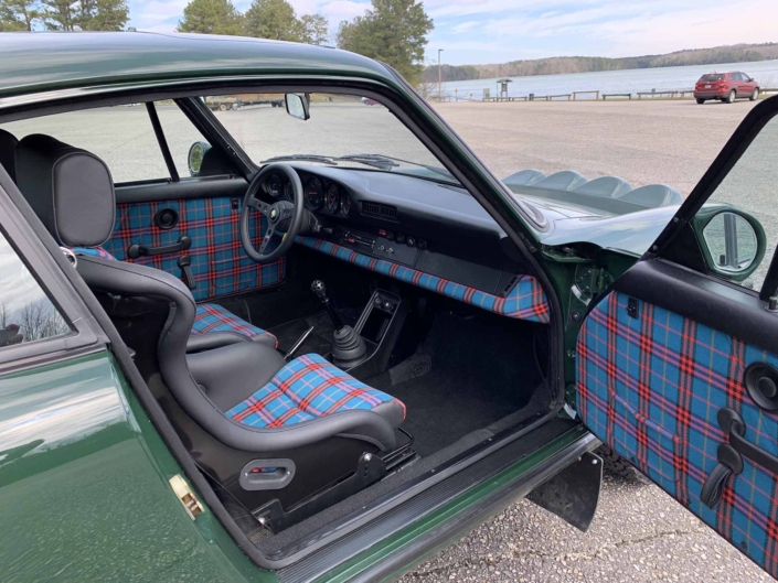 Custom built 1982 Porsche 911 SC in Irish Green with VW tartan interior parked with the door open