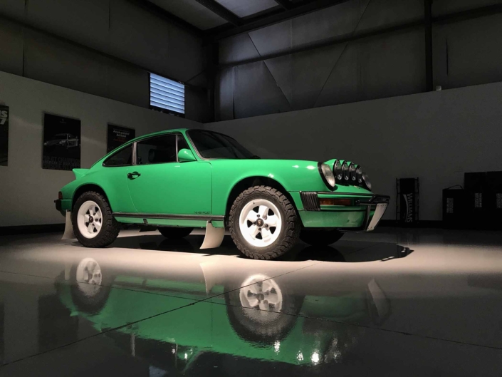 Custom Built 1981 Porsche 911 SC in Signal Green with Porsche Tartan Interior parked in a garage with dramatic lighting