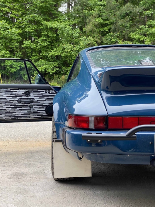 rear view of a Custom Built 1987 Porsche 911 Carrera with Aga Blue exterior and Carrera fabric interior with the door open