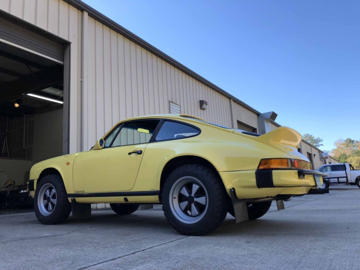 3/4 rear view of a Custom Built 1984 Porsche 911 Carrera Euro with Hellgelb Exterior and Mercedes Tartan Interior