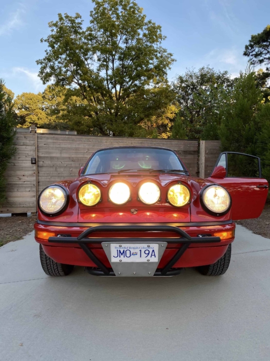 Custom Built 1987 Porsche 911 Carrera with Cherry Red exterior and VW retro interior with the headlights on