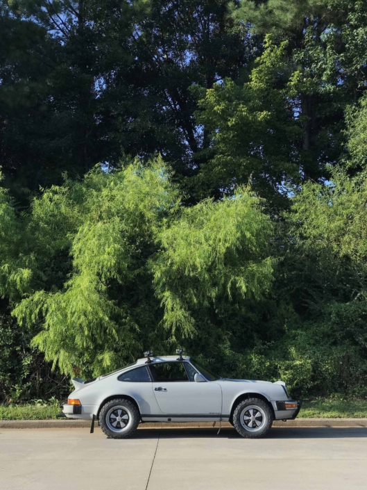 side view of a Custom Built 1986 Porsche 911 Carrera with Fashion Grey Exterior and Lancia Fabric Interior in the woods