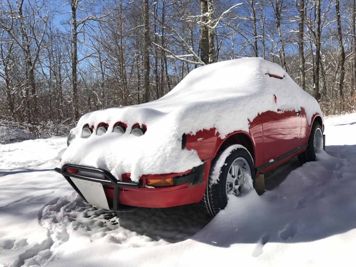 Custom Built 1981 Guards Red Porsche 911 SC covered in snow