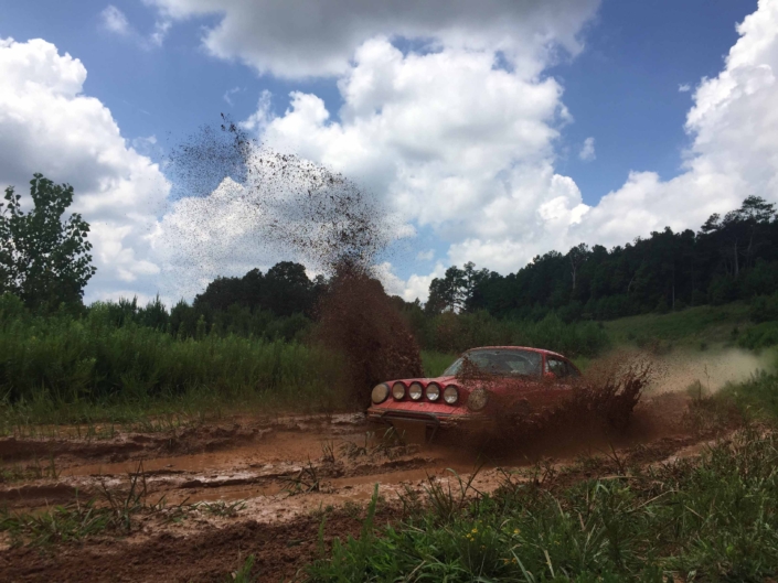 Custom Built 1981 Guards Red Porsche 911 SC driving through the mud