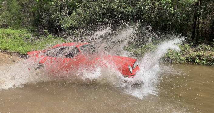 Custom Built 1981 Guards Red Porsche 911 SC driving through water