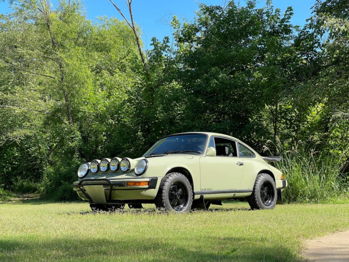 Leh Keen's Custom 1985 911 Carrera in Stone Grey parked in a field